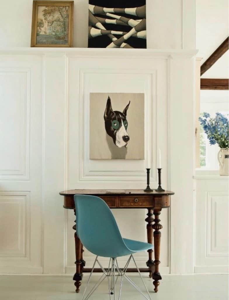 An Antique Kidney Desk and Blue Eames Chair In A Modern Room